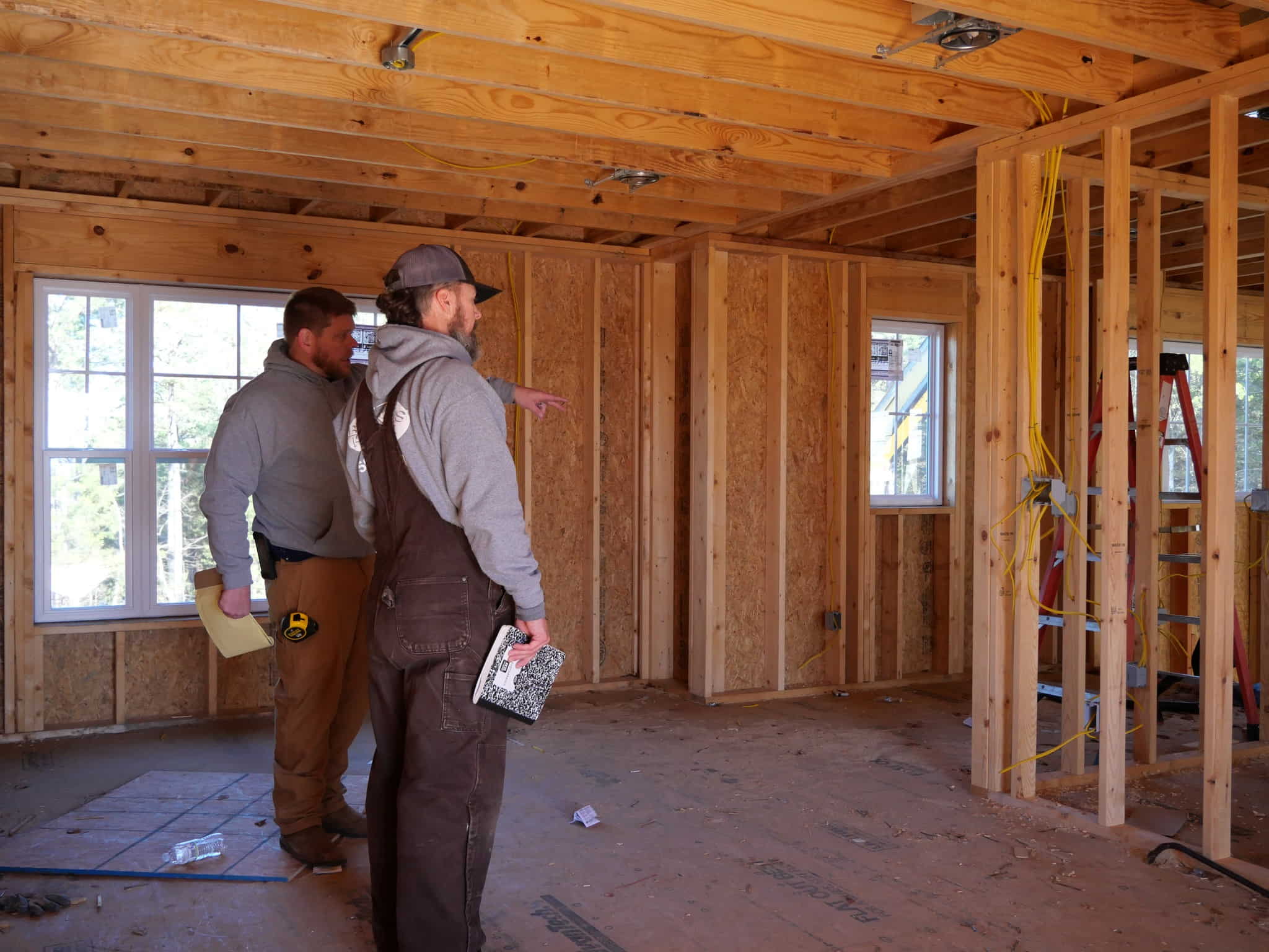 Burris Heat & Air workers discussing their plans inside a residential house during construction.