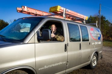 Burris Heat & Air worker inside their van giving thumbs up.